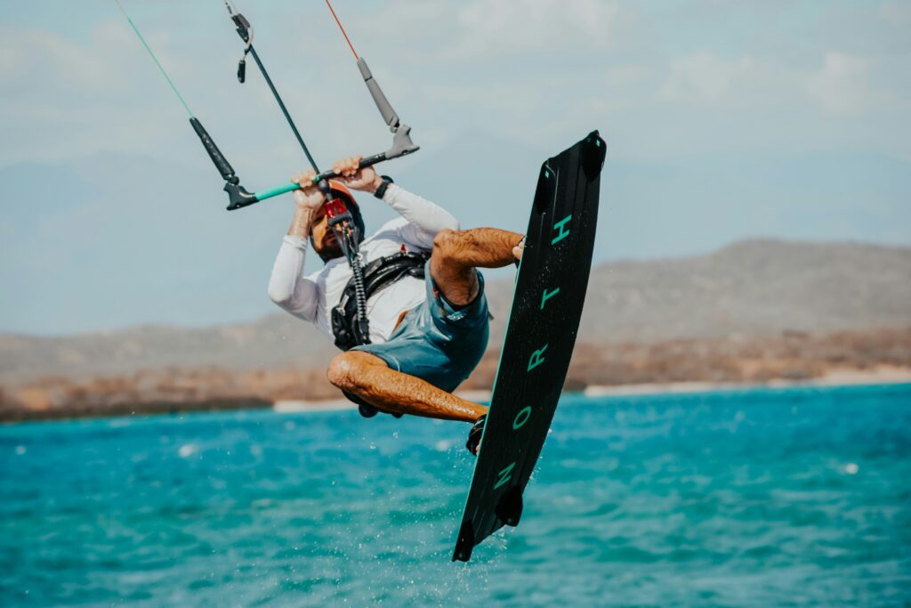 foto captura um kitesurfista executando manobra em Cabarete, na costa norte da República Dominicana—destino caribenho conhecido por ventos constantes, águas quentes e condições ideais para esportes aquáticos radicais. Palavras-chave: kitesurf no Caribe, Cabarete República Dominicana, esporte aquático, destino de aventura, viagem de kite.